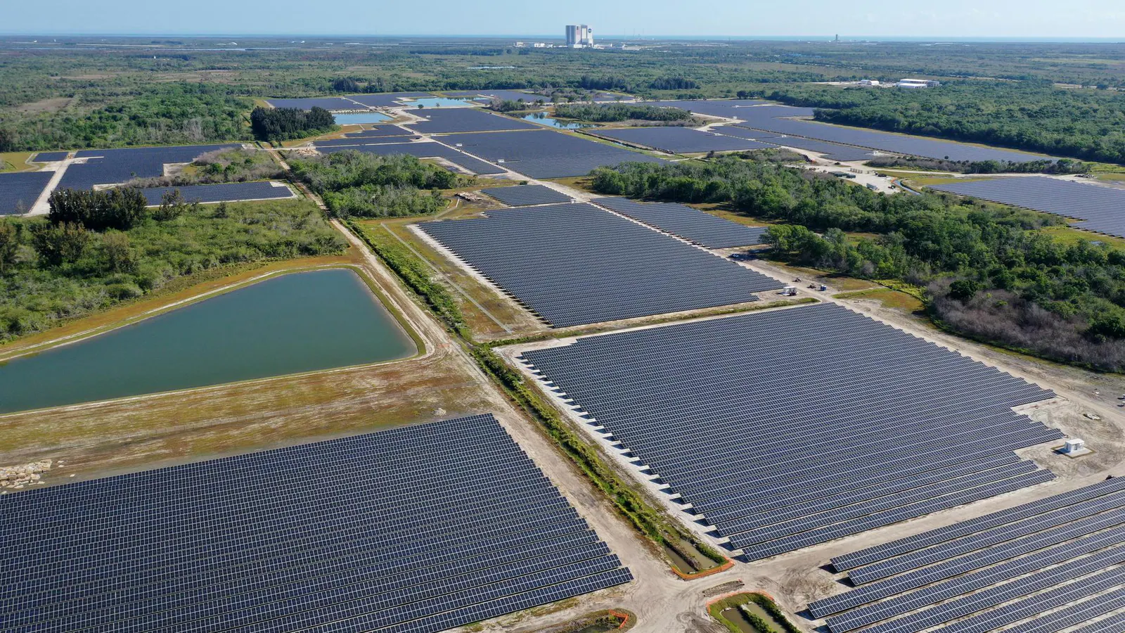 An aerial photograph of rows of photovoltaic panels and retention ponds at the Discovery Solar Energy Center in Florida.